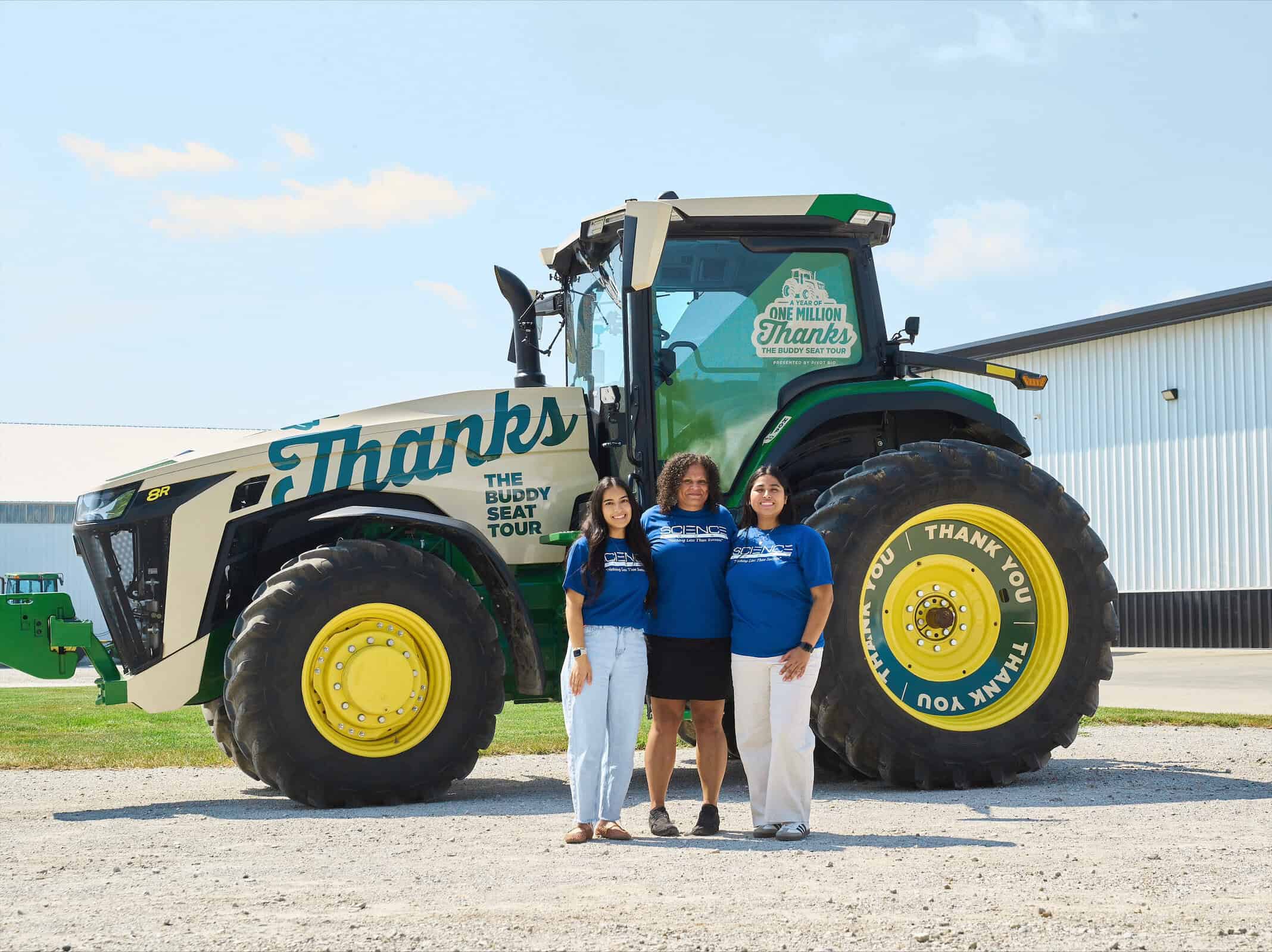 three people standing in front of a tractor